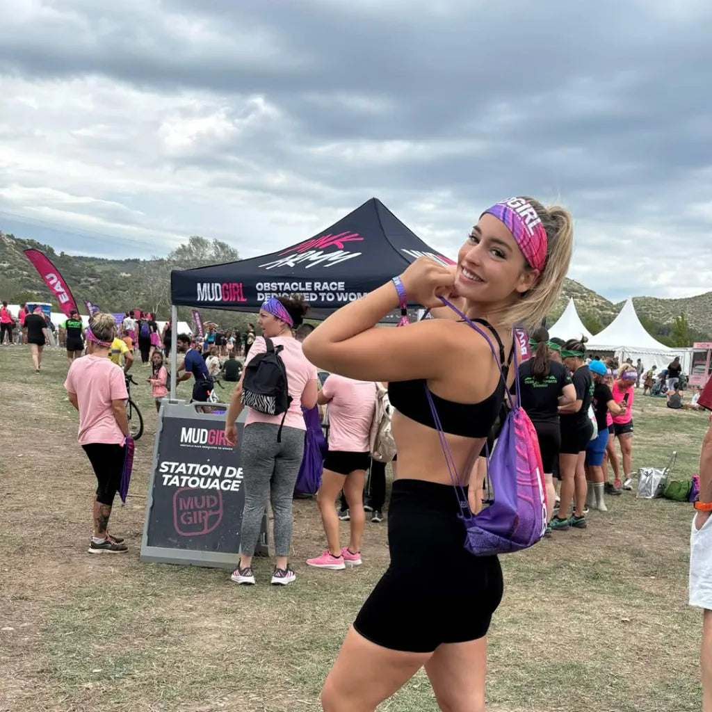 Mylène pose, couverte de boue, à l'arrivée d'une course à obstacles